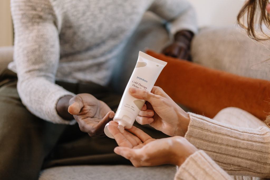 People use CBD topicals to help ease a variety of everyday aches, inflammation and pains. Photo: Two people apply Populum Cold Therapy Hemp Rub, a CBD-infused cream.