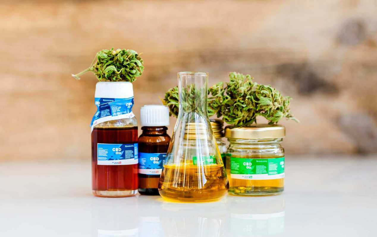 A collection of CBD oil tinctures along with hemp buds and a beaker of CBD oil. Out of hundreds of products available online, we picked the 12 best CBD oil tinctures and reviewed each one.