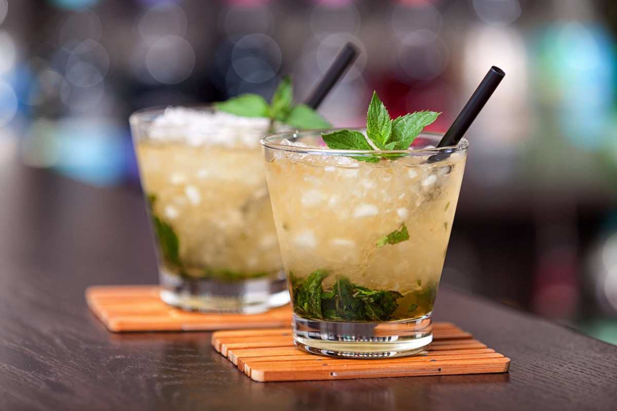 We've included some CBD cocktail recipes to get you started, like these mint juleps. Two mint juleps rest on an elegant bar.