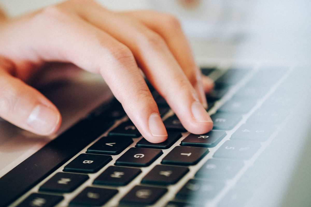 A hand types on a laptop keyboard. Annalise Mabe shared her struggles with the anxiety and chronic pain caused by Crohn's disease, which led others to share their experiences with CBD oil.
