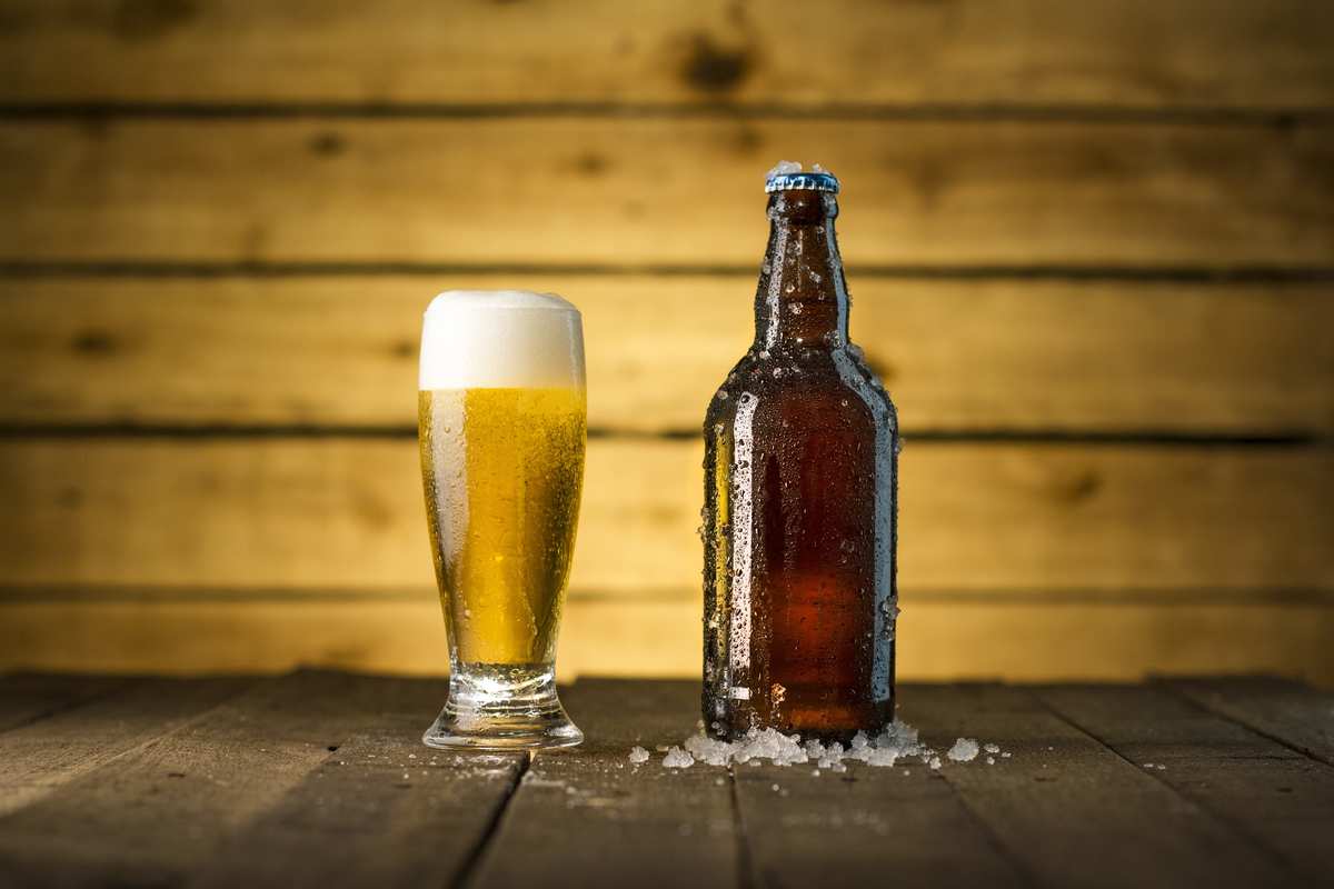 A pale, foamy beer in a glass sits next to a capped brown beer bottle chilling in a small pile of ice. The success of the UK's first CBD beer is likely to lead to more CBD-infused brews in the near future. 