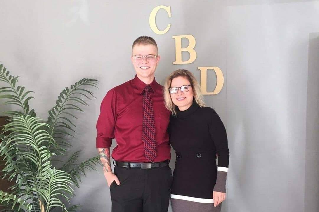 Dreyson and Heather Beguin pose in front of their Scottsbluff, Nebraska CBD shop. Dreyson and his mother Heather Beguin, co-owners of a Nebraska CBD shop, now face felony charges. Police claim that CBD is a "controlled substance."