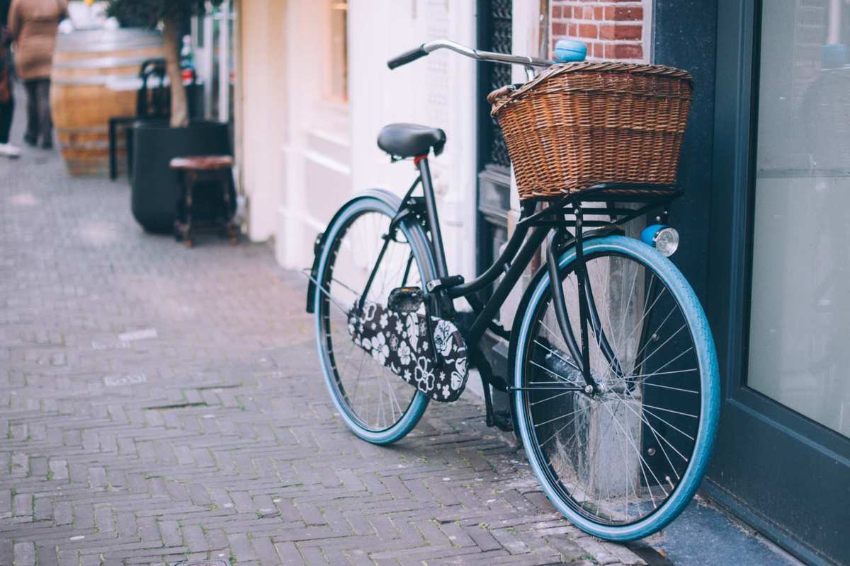 A bicycle with basket, bell, and flower-print decorations leans against a wall. A cycling accident left Haddayr Copley-Woods hurting, and started her on a journey towards discovering CBD oil's benefits.