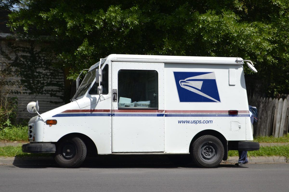 A USPS mail truck parked by the side of the road. Thanks to the 2018 Farm Bill and Courtney Moran's recent legal victories, the law will protect your right to send hemp by mail.