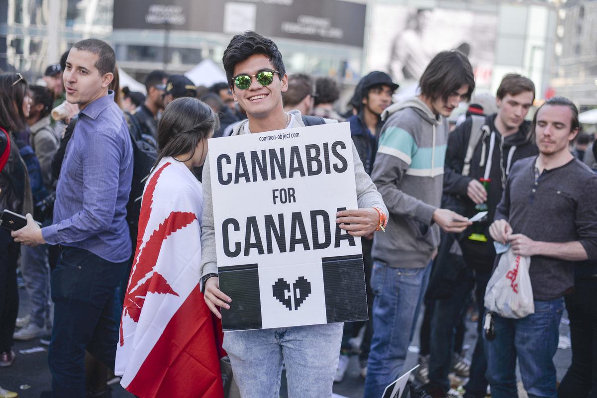 An activist holds a "Cannabis for Canada" sign at a 420 celebration. Despite legalization of recreational cannabis, it's still difficult to obtain legal CBD in Canada.