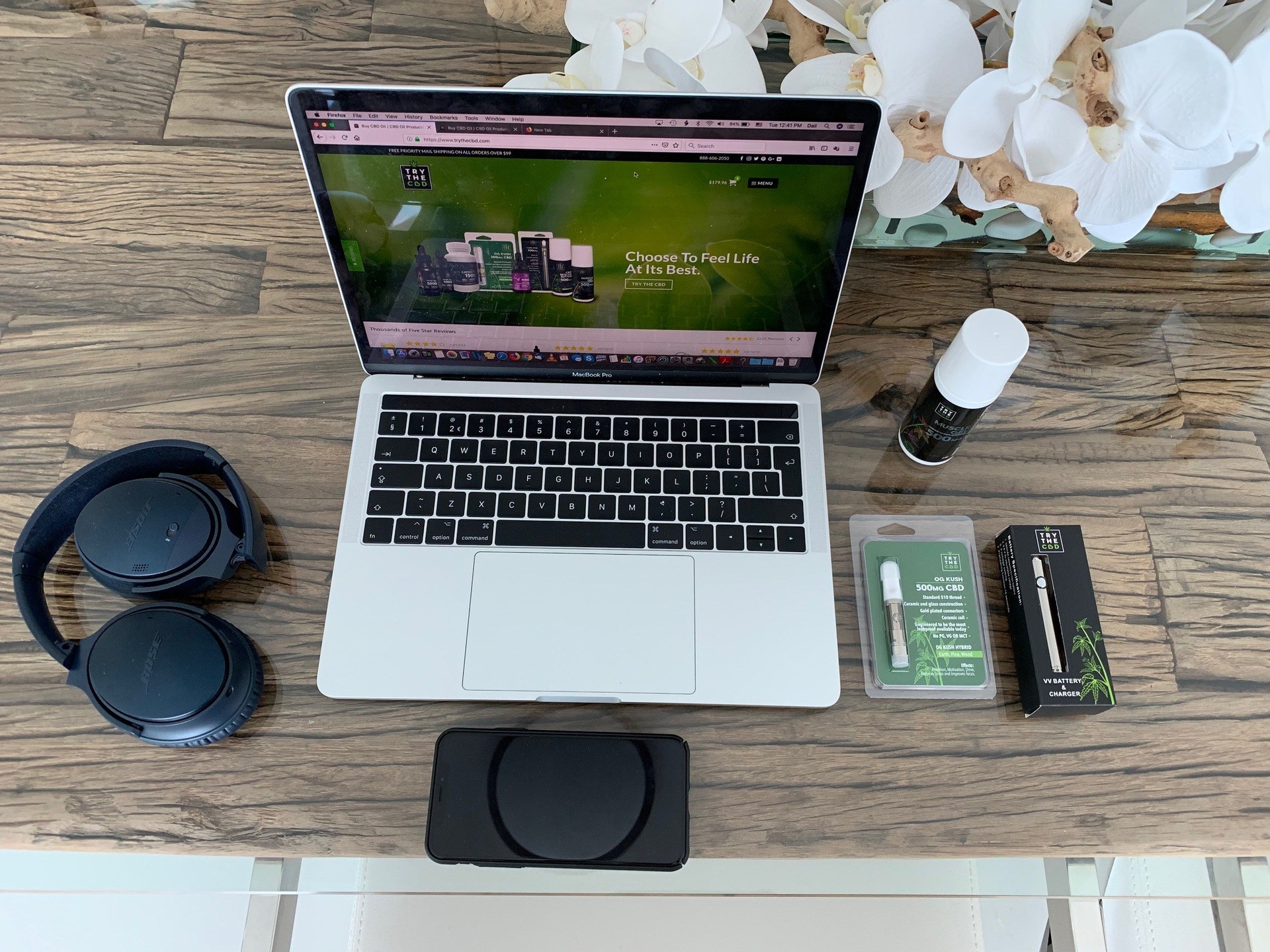 TryTheCBD Vape Cartridges combine CBD isolate with plant-based terpenes in a special carrier fluid free of common irritants, for smooth delicious vaping. Photo: TryTheCBD Vape Cartridges and other TryTheCBD products posedaround a laptop on a wooden desk, with headphones nearby.