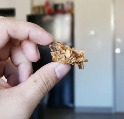 You can eat our hemp granola by the handful, or mix it with milk or yogurt. Photo: A hand holds a chunk of hemp granola.