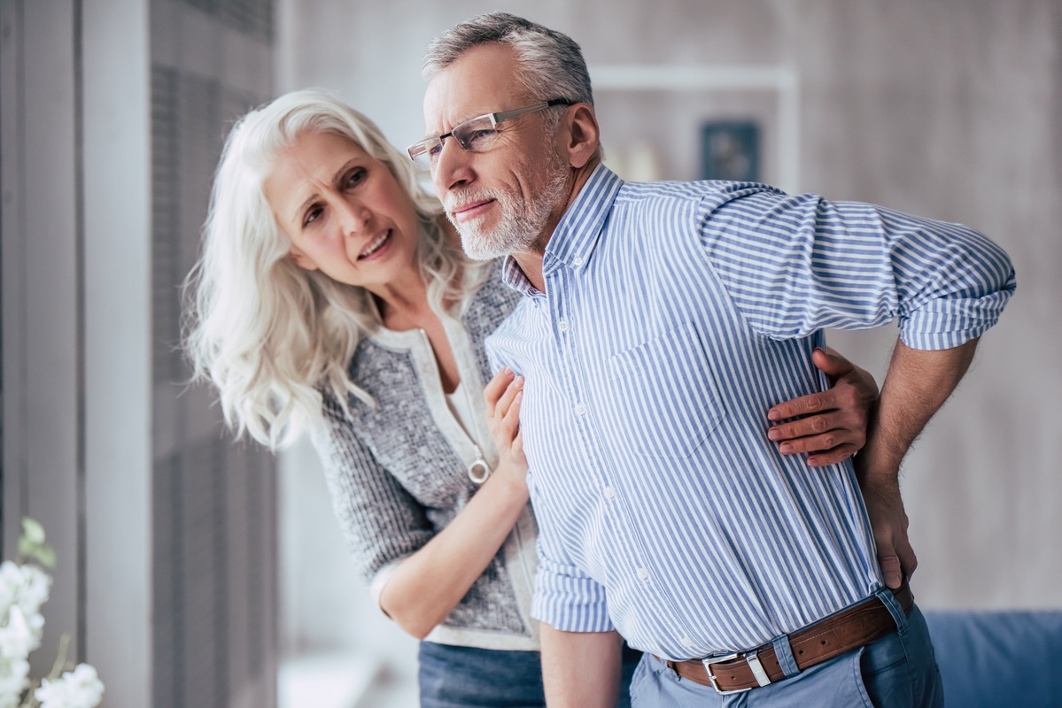 While CBD may offer pain relief, knowing how to pick the best CBD oil for pain can be confusing. Photo: An older woman helps an older man who is clutching his back in pain.