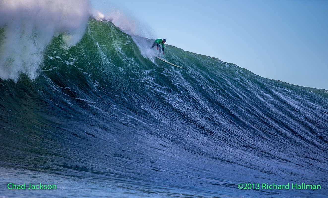 Jackson catches a massive wave on a hemp surfboard.