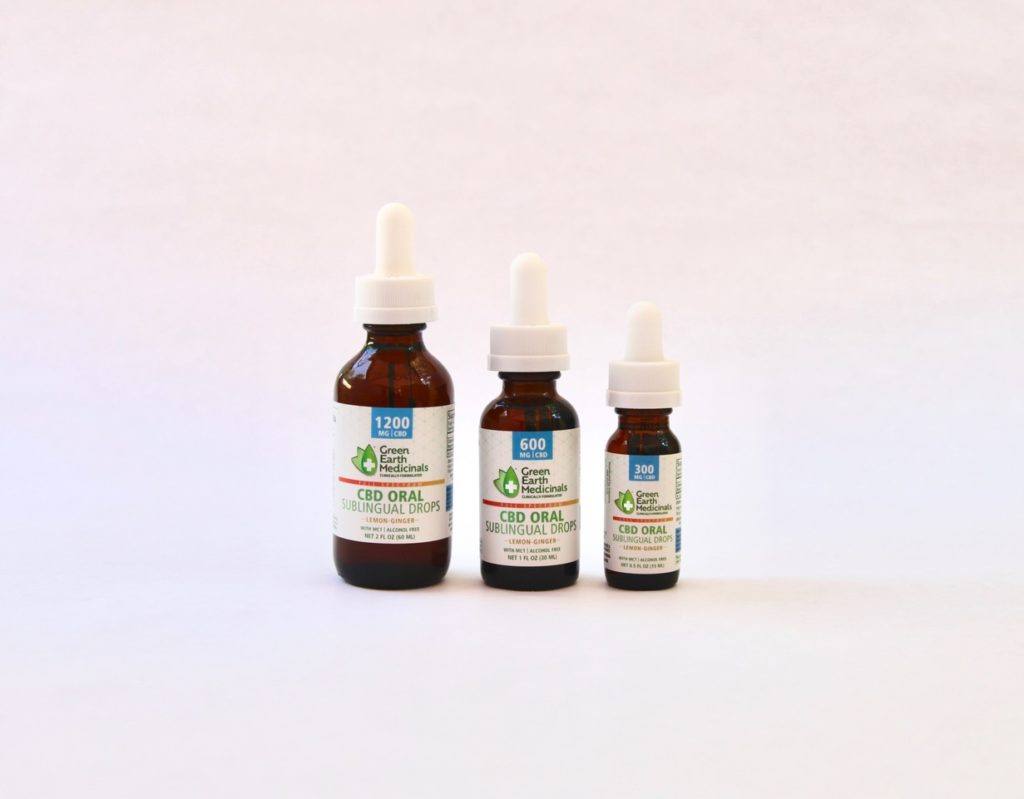 Three different sized bottles of Green Earth Medicinals CBD Oral Sublingual Drops against a lightly colored background.