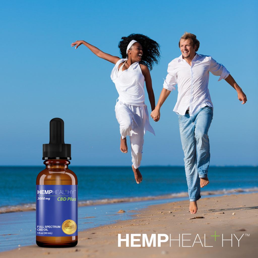 A couple runs on the beach together, dressed in white shirts. A bottle of Hemp Healthy Full Spectrum CBD Oil is shown.