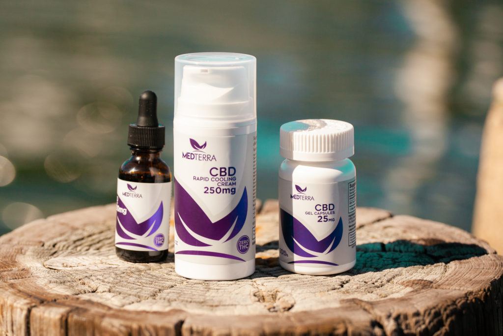 Like all Medterra products, their CBD Cooling Cream offers top quality CBD relief at an affordable price. Photo: Medterra CBD Cooling Cream with Medterra's CBD oil and capsules, arranged on a tree stump outdoors.