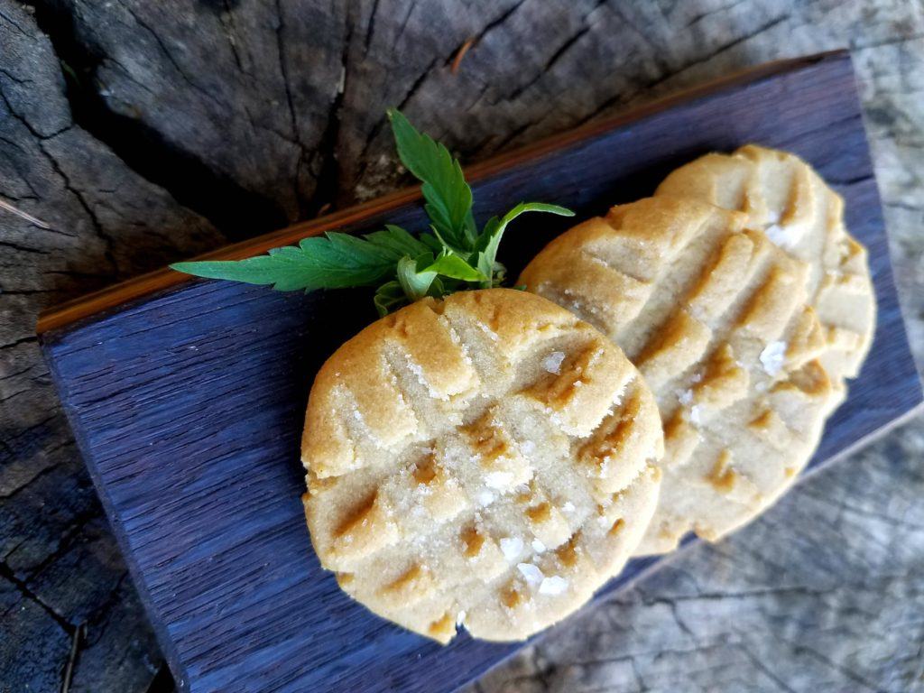 Cannabis-infused bacon fat makes a perfect carrier for cannabinoids in all kinds of recipes, like these delicious peanut butter cookies. Photo: Peanut butter cookies garnished with a hemp leaf on a board on display.