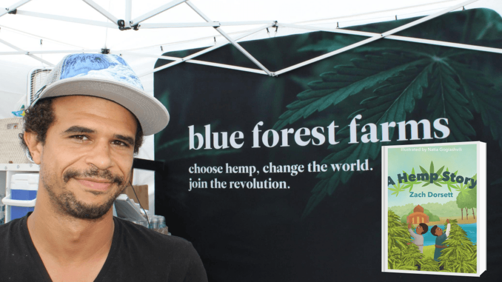 Photo: A photo of Zach Dorsett under a Blue Forest Farms awning. The motto reads "choose hemp. change the world. join the revolution." Also pictured is his hemp children's book, "A Hemp Story."