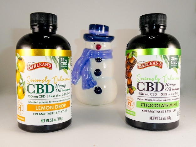 Barlean's Seriously Delicous CBD syrups in lemon drop and chocolate mint, with a decorative porcelan snowman.