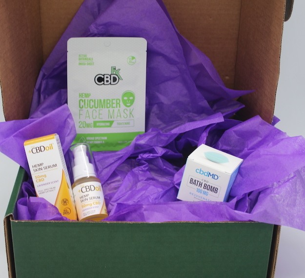 Green Wellness Life skin soother gift box CBD skin care products with purple tissue paper for decoration.