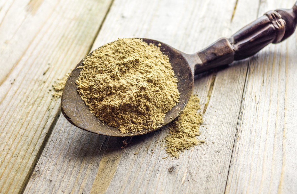 We compared the relative benefits of CBD and kava kavas. Photo: A spoonful of powdered kava root resting on a wooden table.