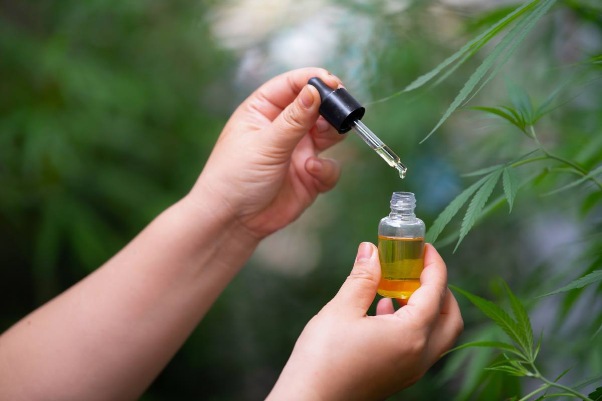 In the Ministry of Hemp podcast, we meet Jess Reynolds, a CBD specialist. Plus, how do you know the right dose of CBD? Photo: A pair of hands holding an unlabeled bottle of hemp extract and a dropper top, with hemp plants growing in the background.