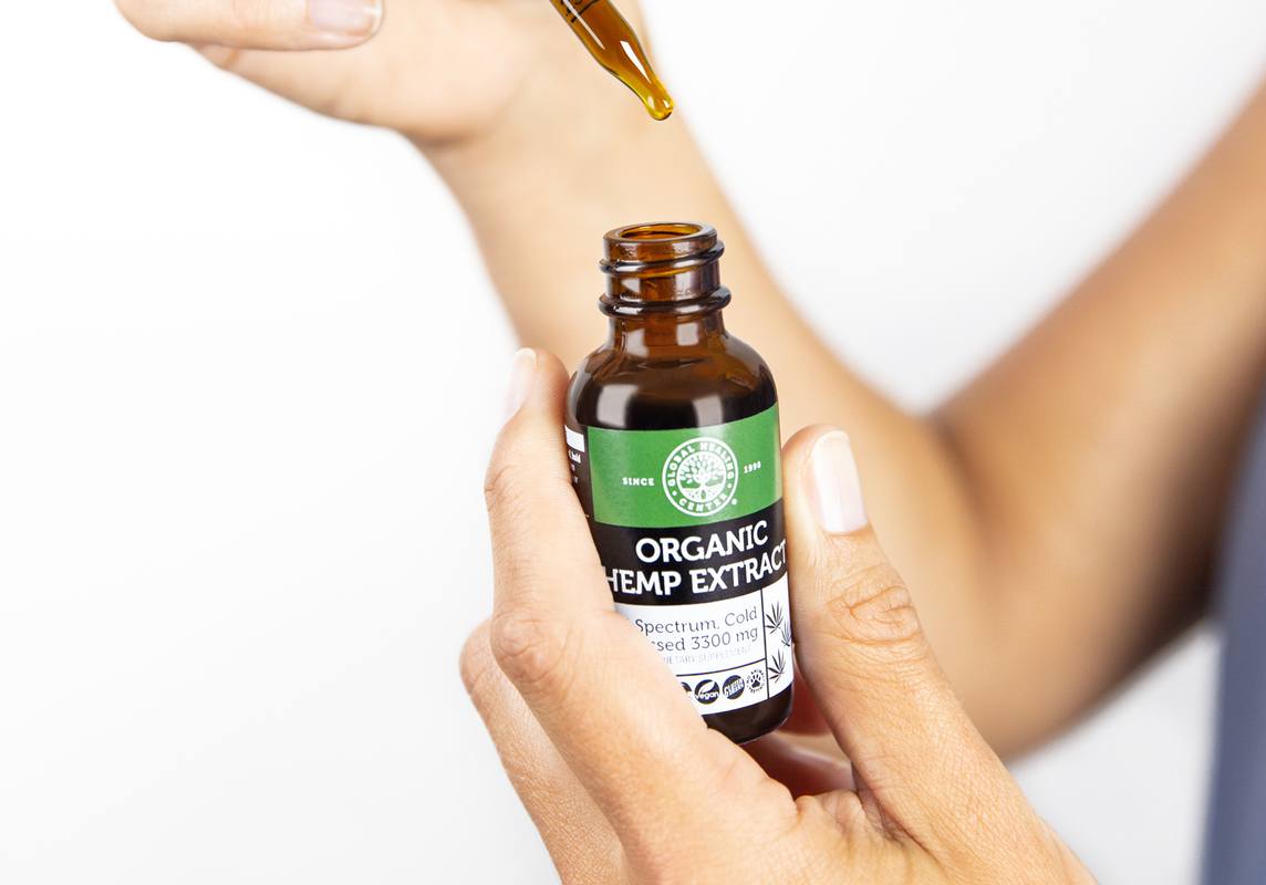 Global Healing Center Organic Hemp Extract packs a potent 2000+ mg of CBD into each bottle. Photo: A pair of hands holding a bottle of Global Healing Center Hemp Extract and the dropper top.